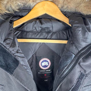 Canada Goose black parka jacket with logo patch and fur-trimmed hood.