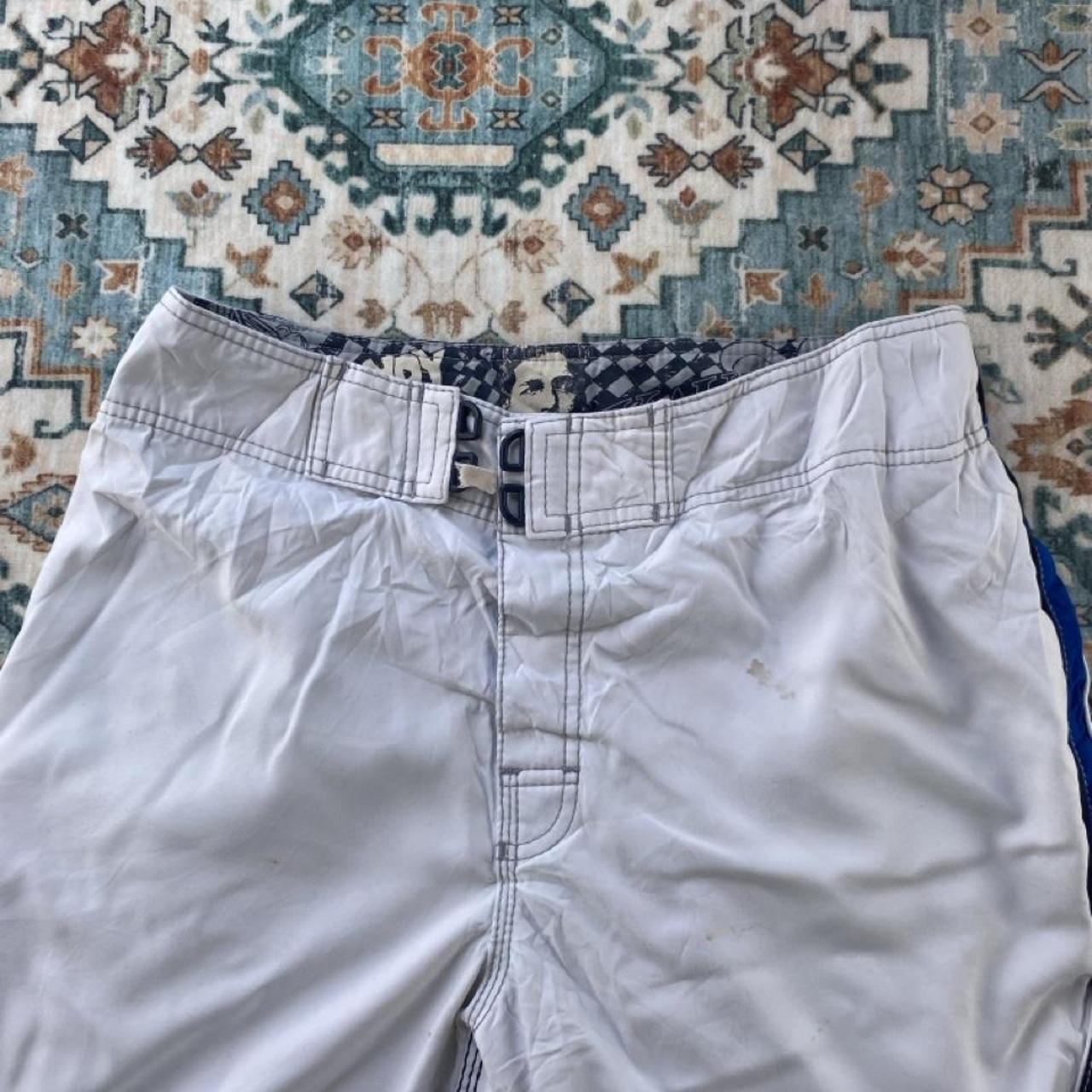 Billabong board shorts blue with tropical print and Andy Irons logo detail.
