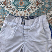 Billabong board shorts blue with tropical print and Andy Irons logo detail.