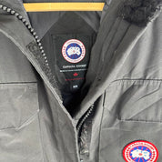 Canada Goose black parka jacket with logo patch and fur-lined hood.