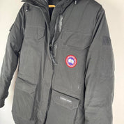 Canada Goose black parka jacket with logo patch and fur-lined hood.