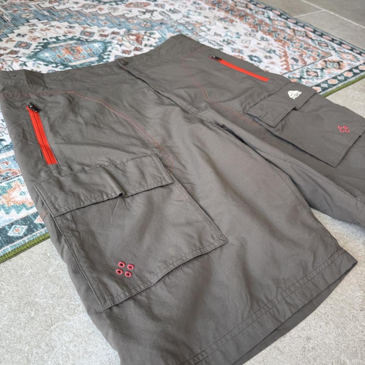Nike ACG grey cargo shorts with multiple pockets and embroidered logo detail.