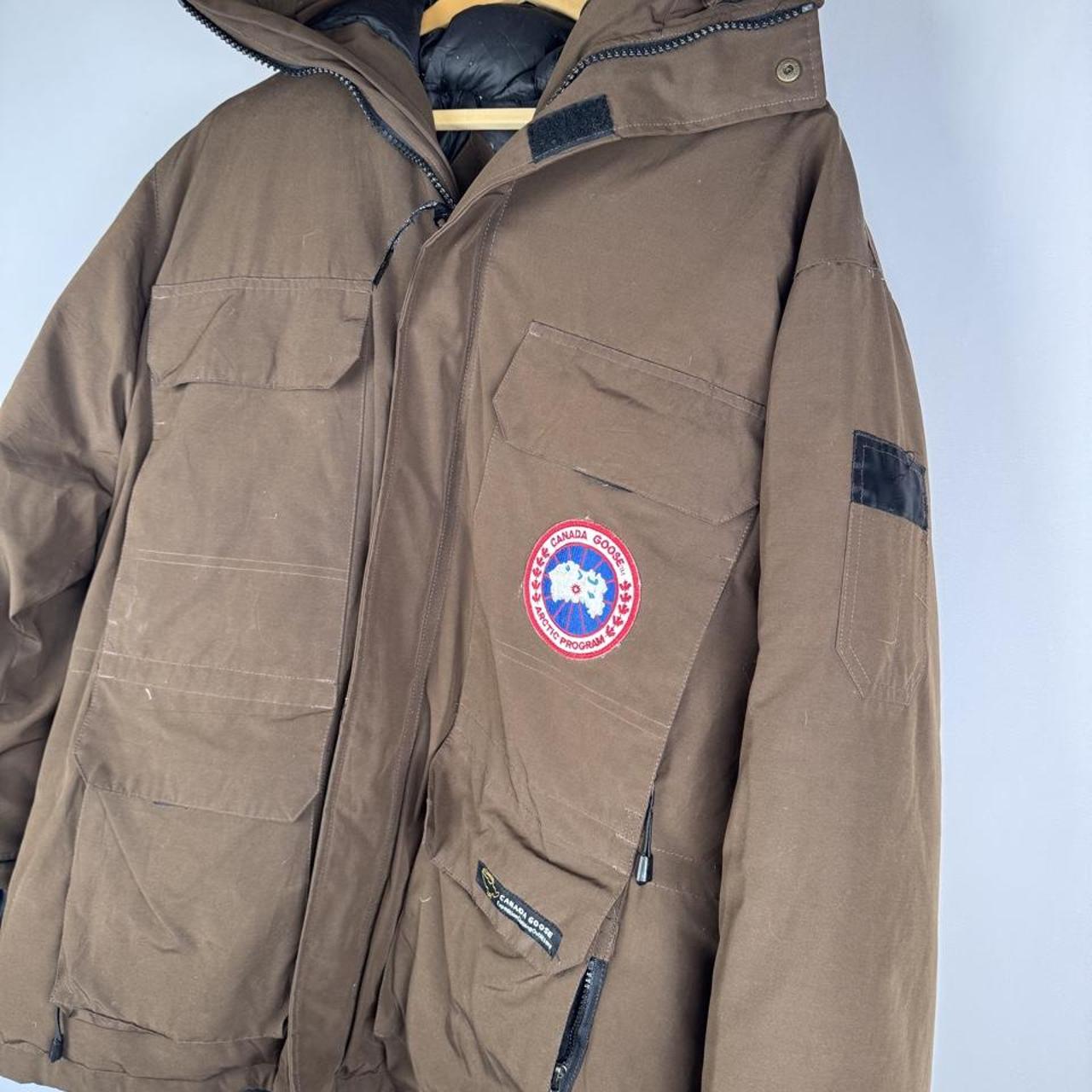 Canada Goose brown parka jacket with utility pockets and logo patch.