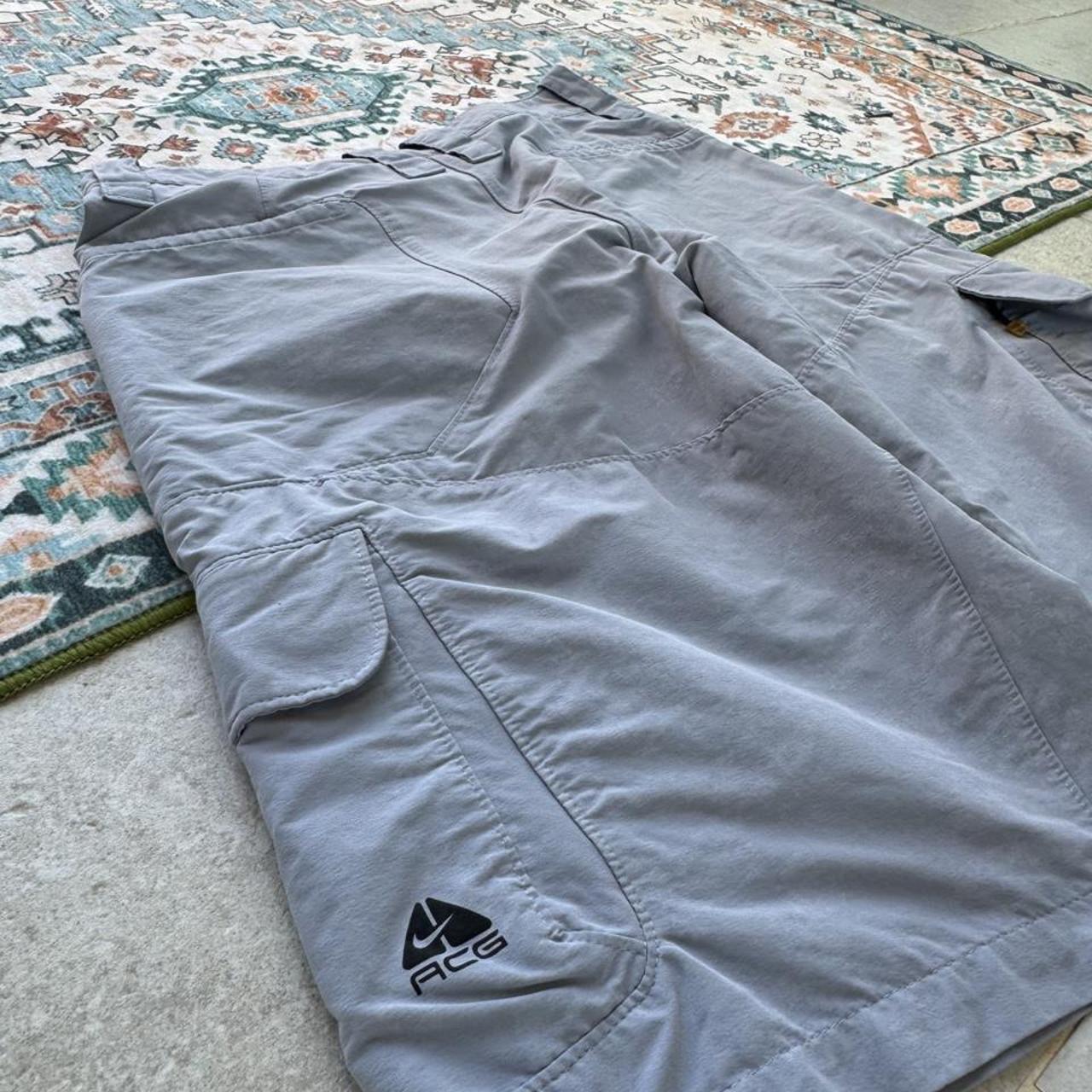 Nike ACG grey cargo shorts with multiple pockets and logo detail.