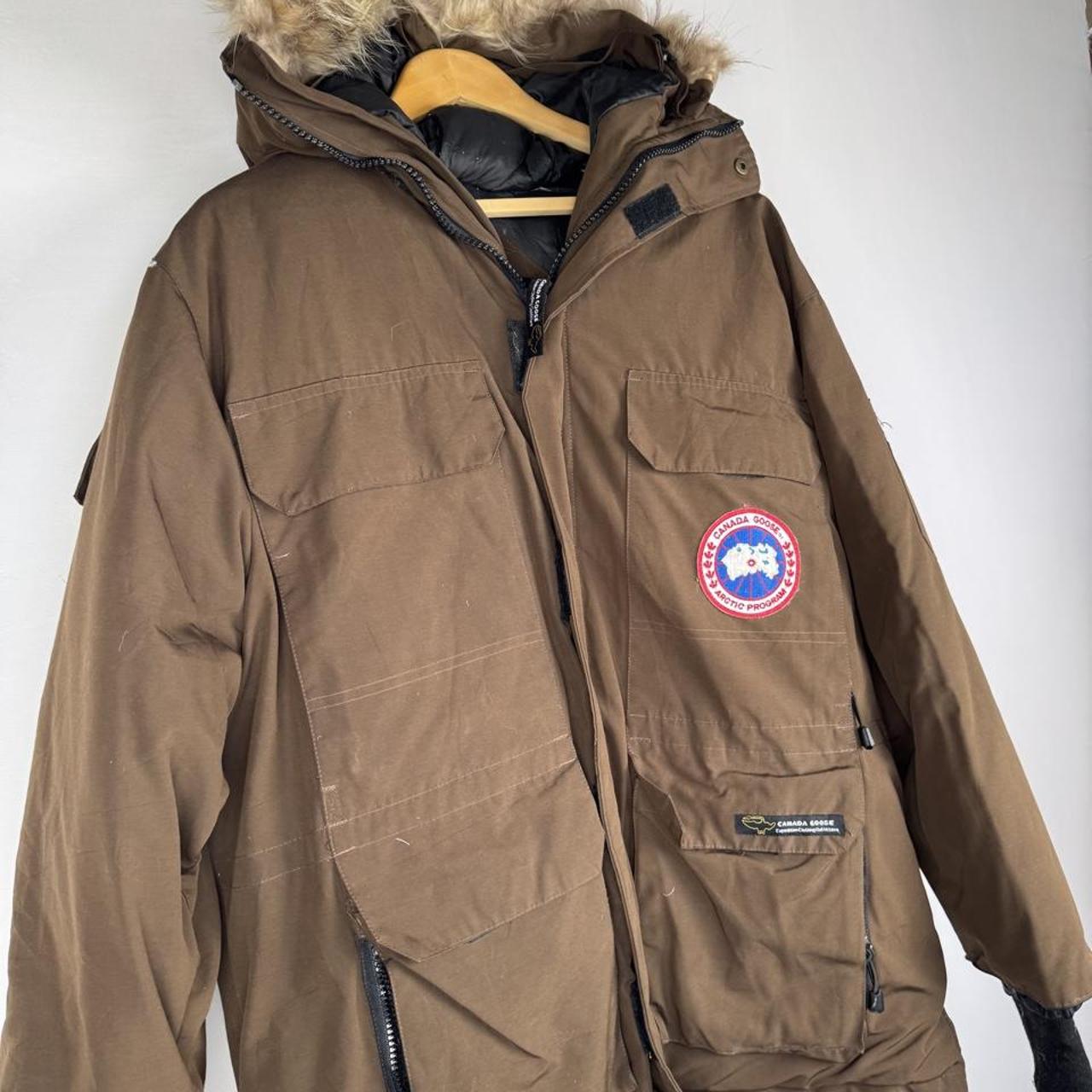 Canada Goose brown parka jacket with utility pockets and logo patch.