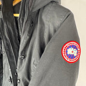 Canada Goose black parka jacket with logo patch and fur-lined hood.