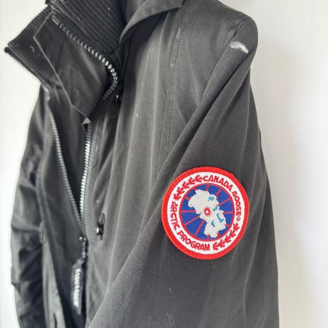 Canada Goose black parka jacket, medium size, features logo patch and sleek design.