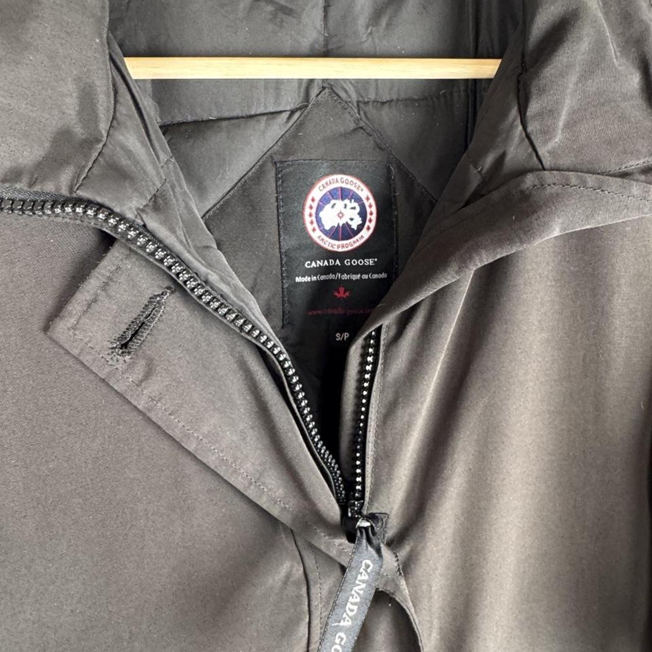 Canada Goose black parka jacket with logo, slight tear near pocket, missing hood.