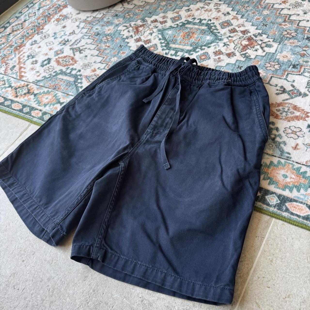 Carhartt WIP navy shorts with logo patch and durable cotton material.