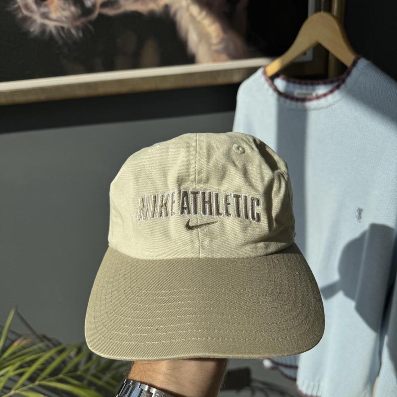 Nike cream cap with embroidered logo and adjustable strap.
