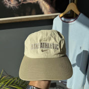 Nike cream cap with embroidered logo and adjustable strap.