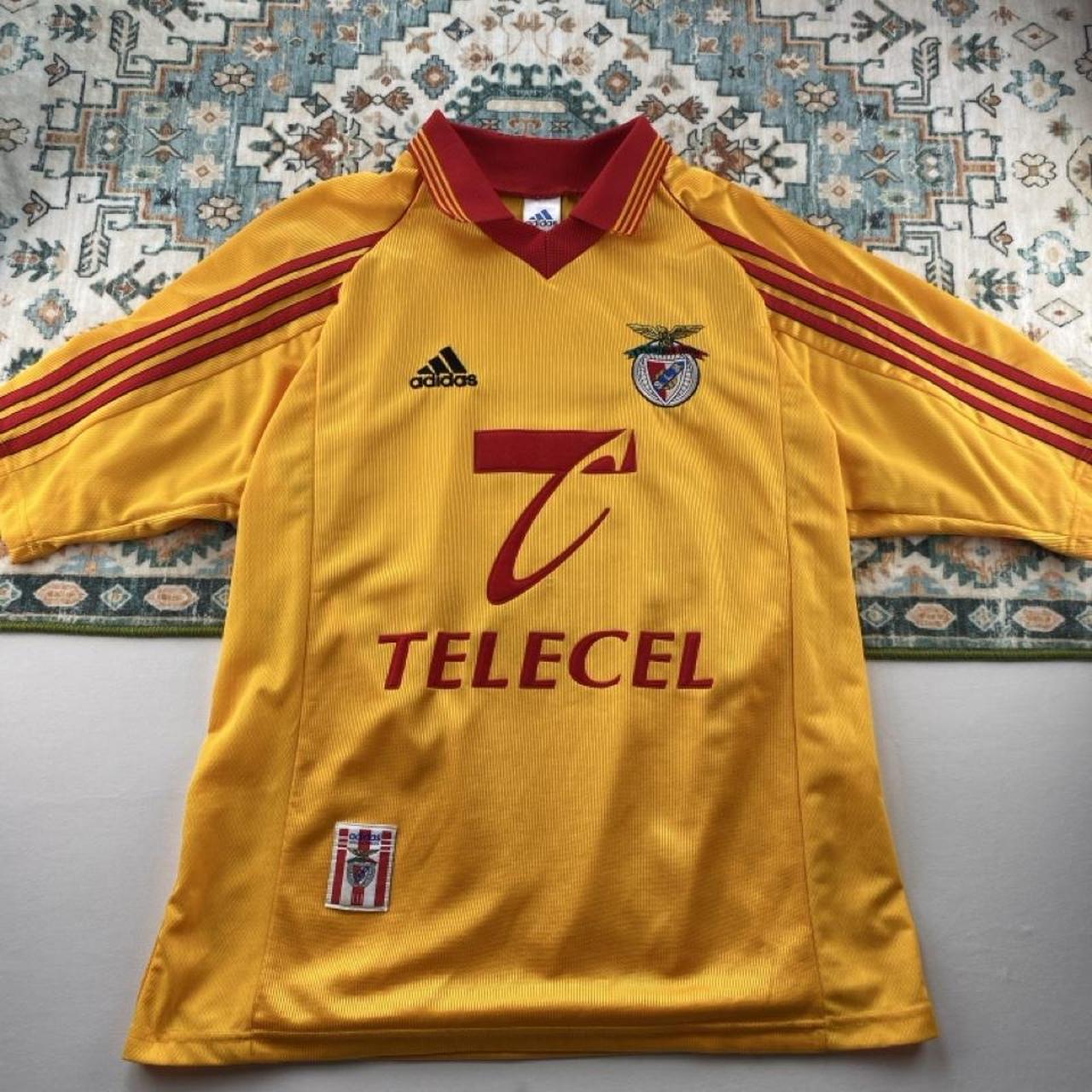 Adidas orange Benfica away jersey with embroidered logo and vintage design details.