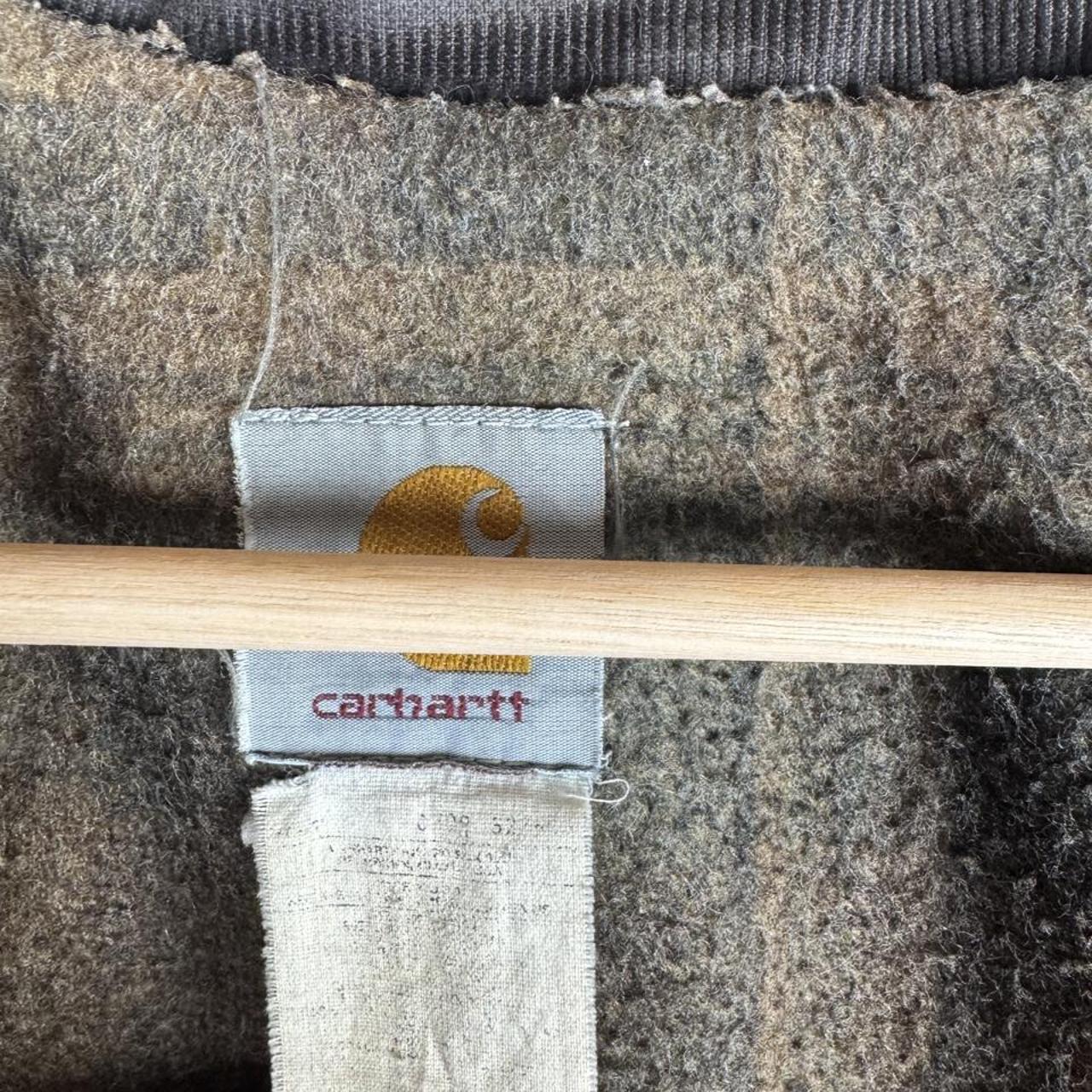 Carhartt oversized chore jacket in brown with classic logo patch and durable fabric.