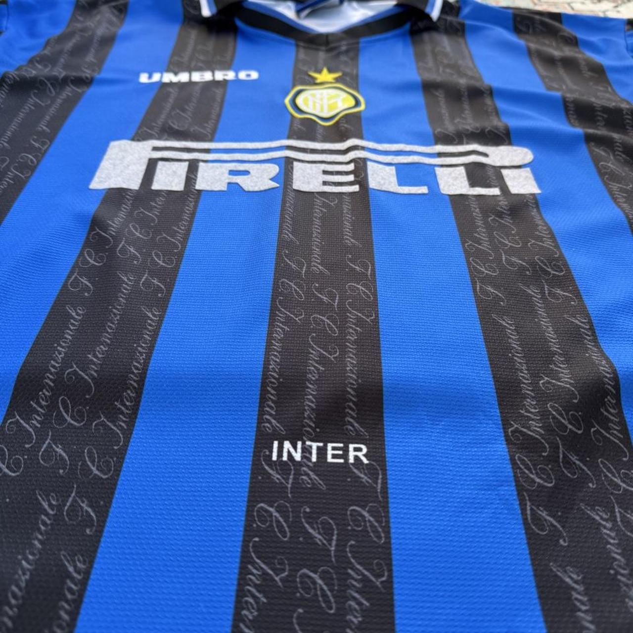 Umbro blue and navy striped home jersey with embroidered logo and vintage design.
