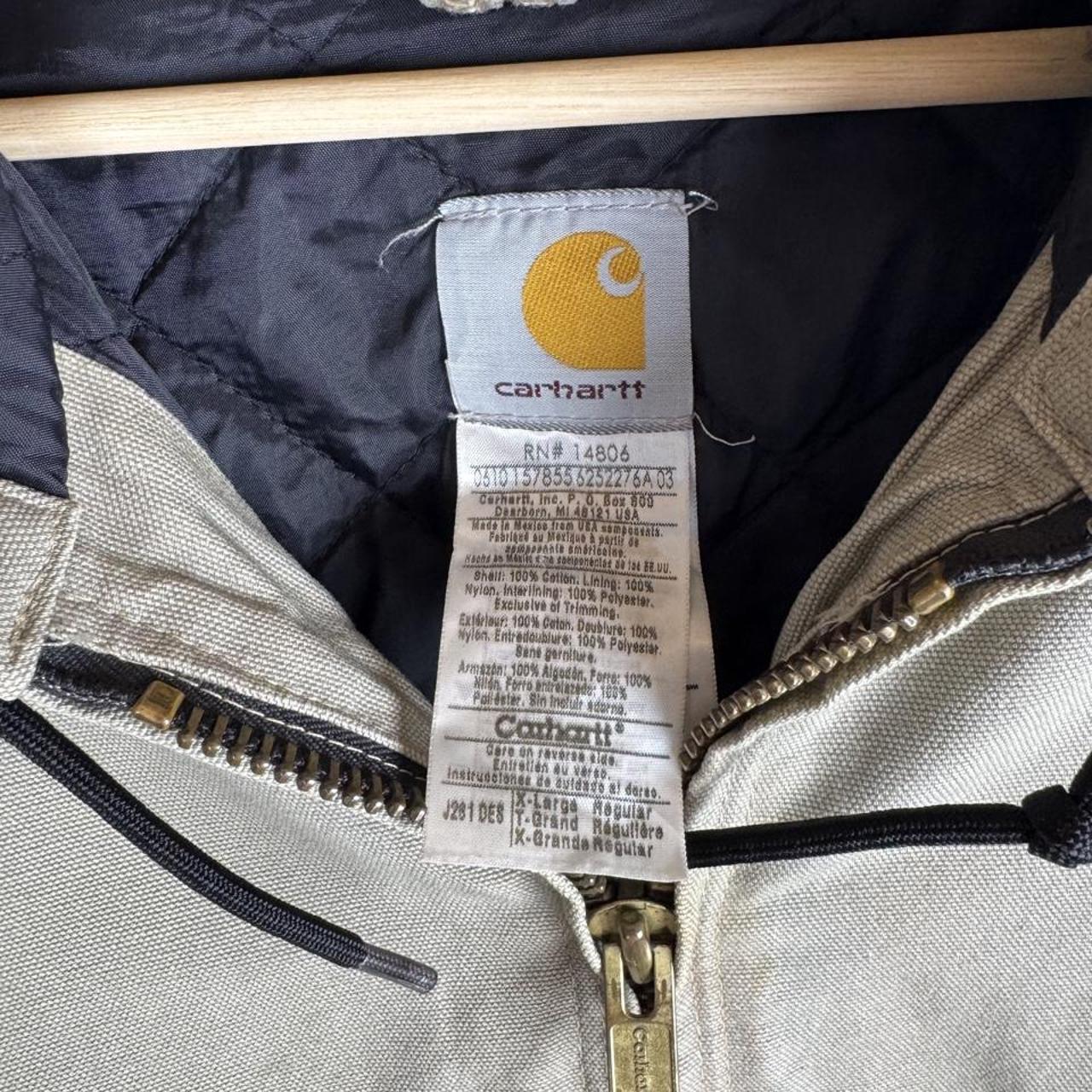 Carhartt active jacket, orange, oversized fit, visible logo, durable material.