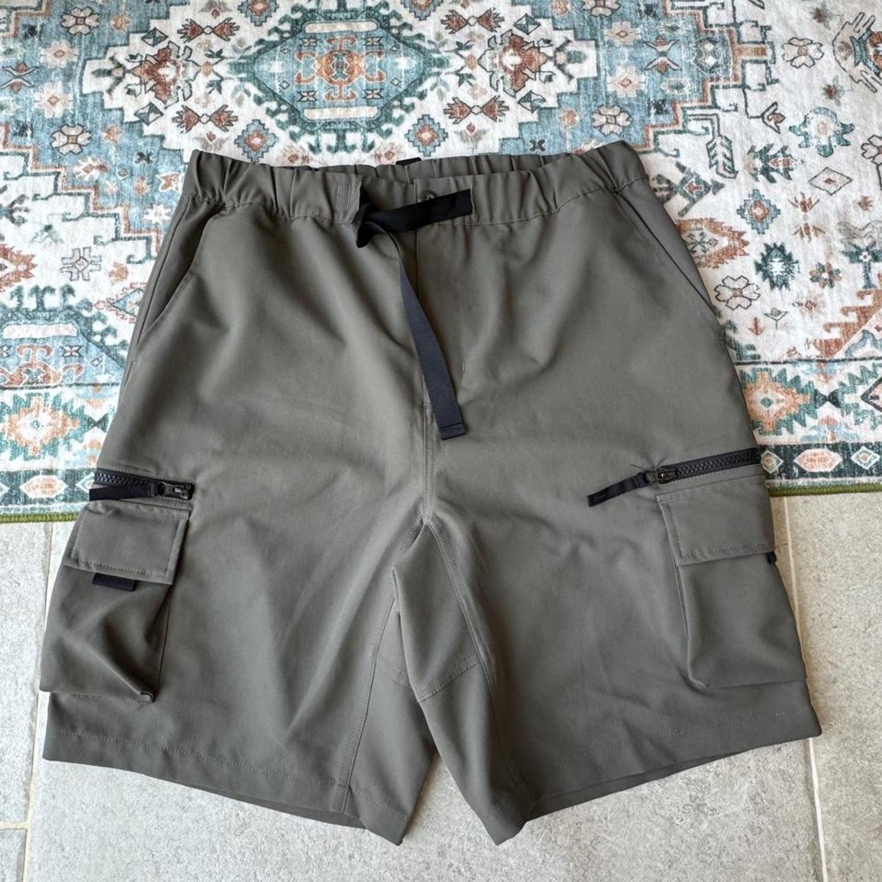 Carhartt WIP olive green cargo shorts with multiple pockets and logo patch.