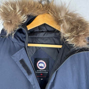 Canada Goose navy parka jacket with logo patch and fur-lined hood.