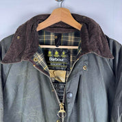 Barbour green waxed Beaufort jacket with attached hood and classic logo detail.