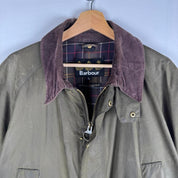 Barbour green wax jacket with logo, classic design, and durable material.
