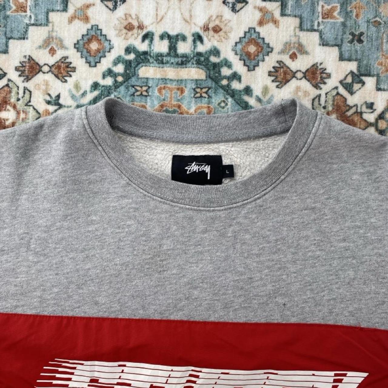 Stüssy grey sweatshirt featuring international logo and soft cotton material.