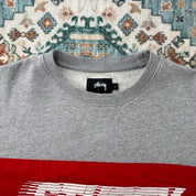 Stüssy grey sweatshirt featuring international logo and soft cotton material.