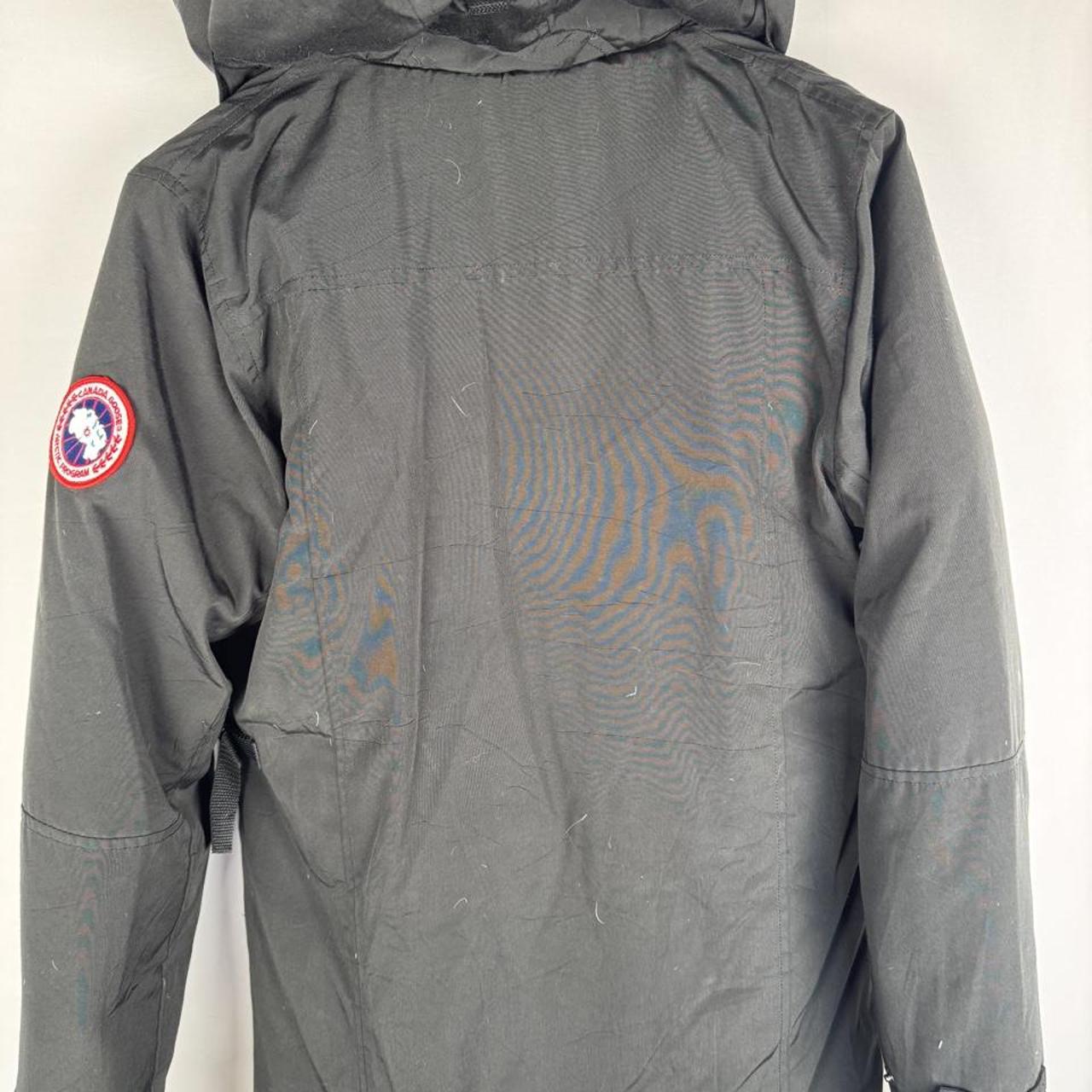 Canada Goose black parka jacket, medium size, features logo patch and sleek design.