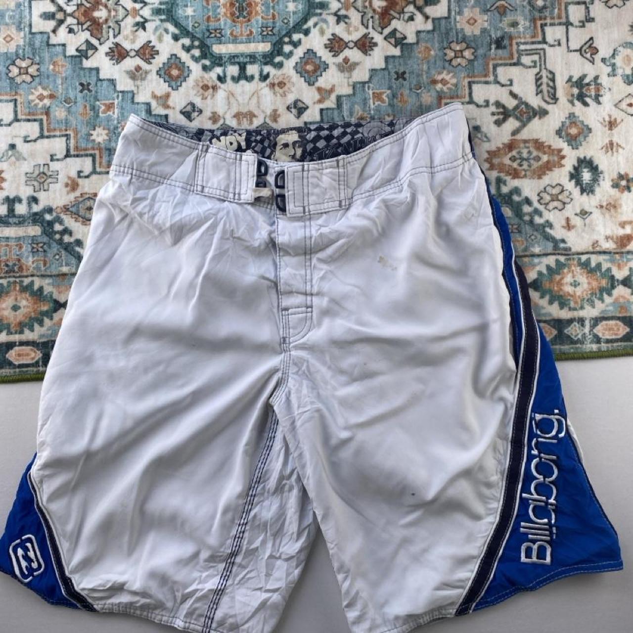 Billabong board shorts blue with tropical print and Andy Irons logo detail.