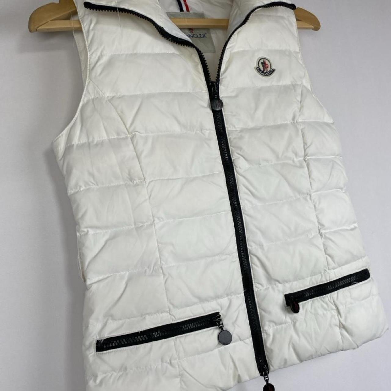 Moncler white down puffer gilet with logo detail and missing belt.