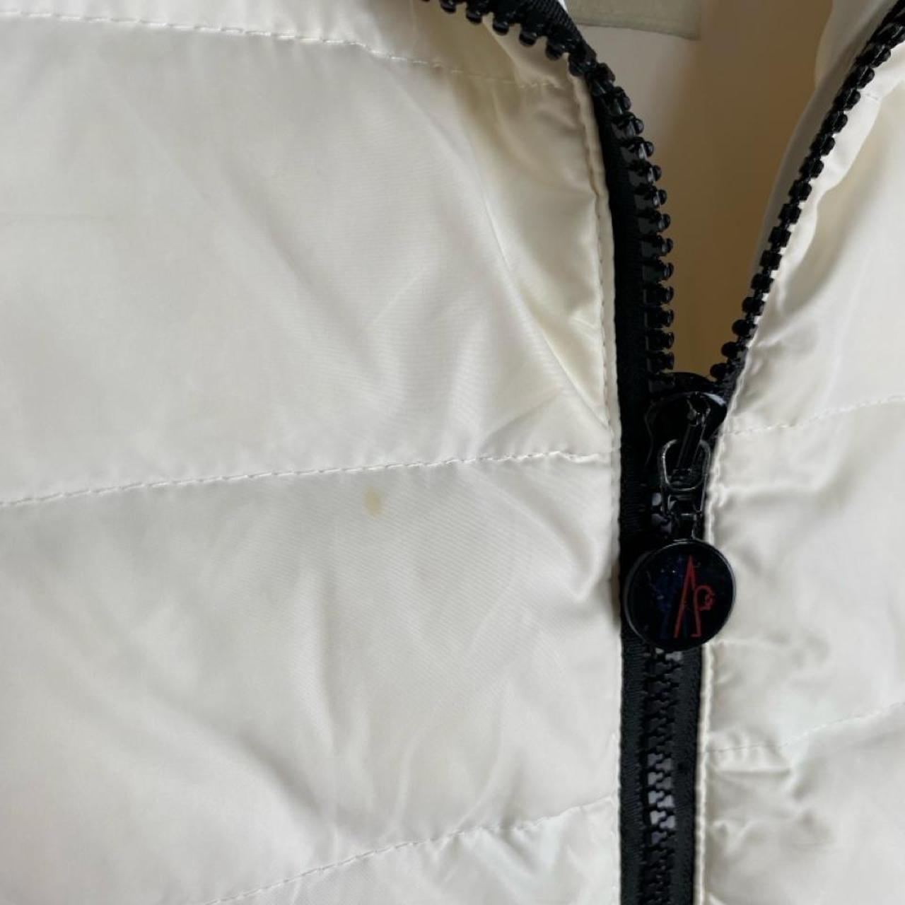 Moncler white down puffer gilet with logo detail and missing belt.