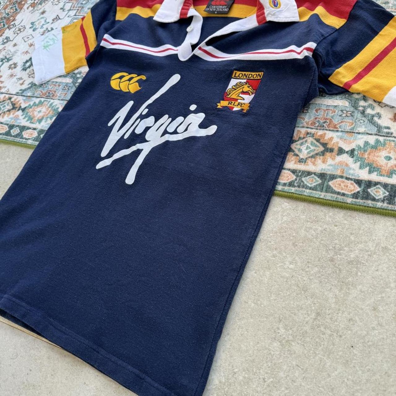 Canterbury men's polo shirt blue with embroidered London Broncos logo and signature.
