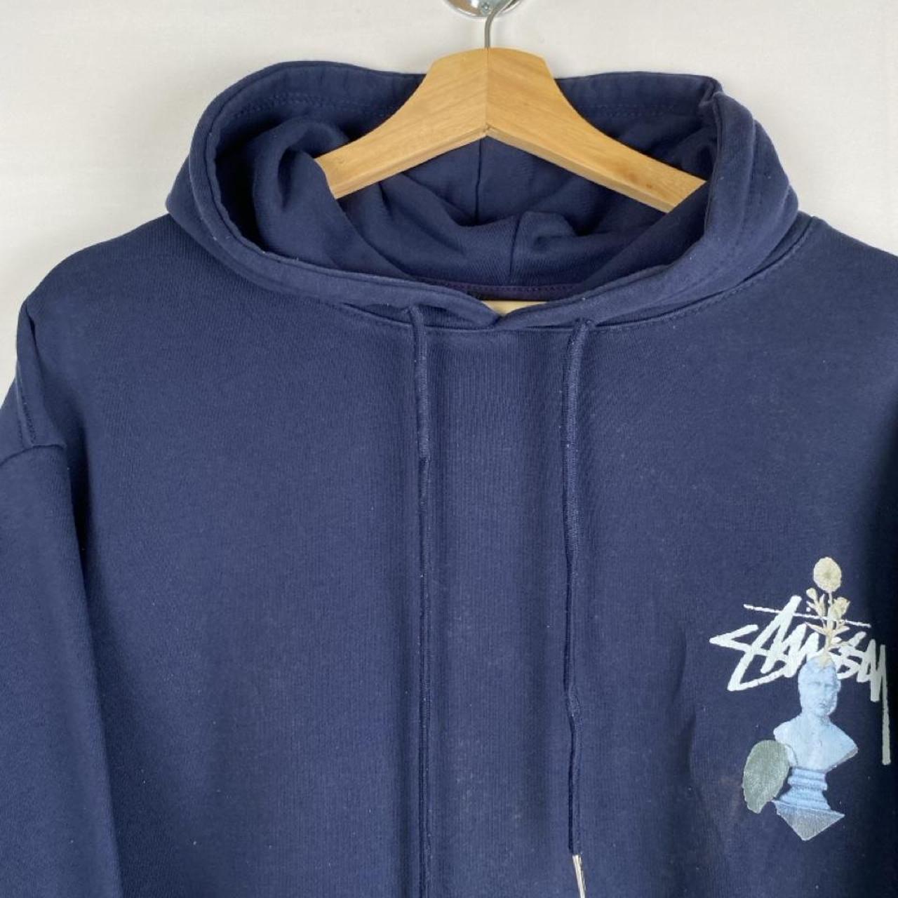 Stüssy black hoodie with stone statue graphic and logo print.