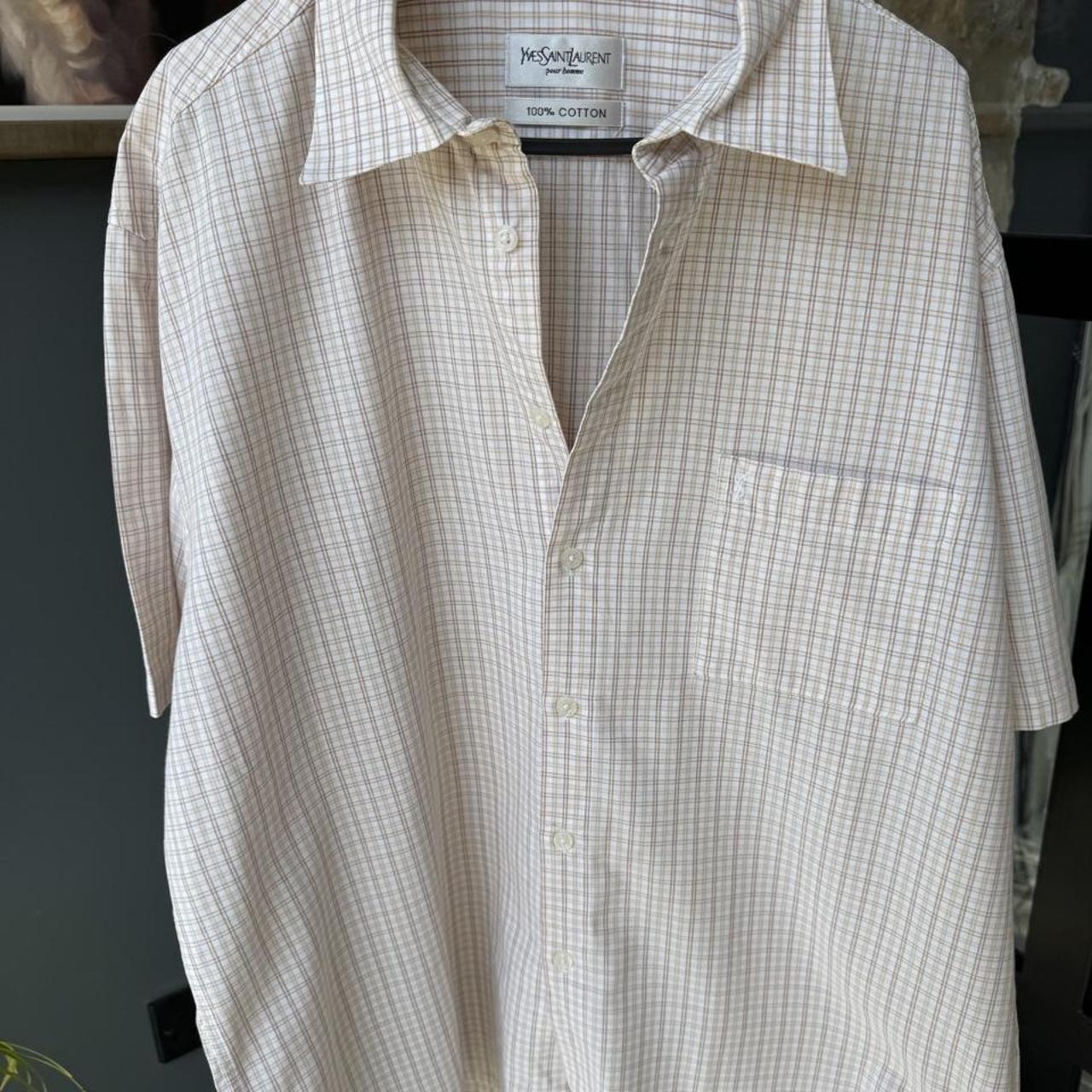 Yves Saint Laurent cream short sleeve shirt with embroidered YSL logo and button details.