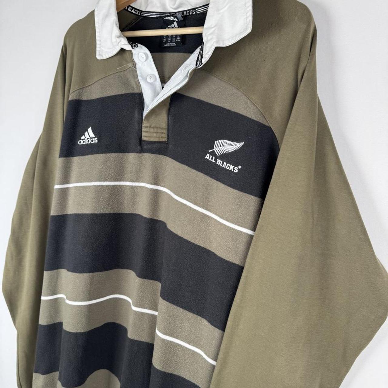 Adidas cream rugby polo with striped pattern and New Zealand All Blacks logo.