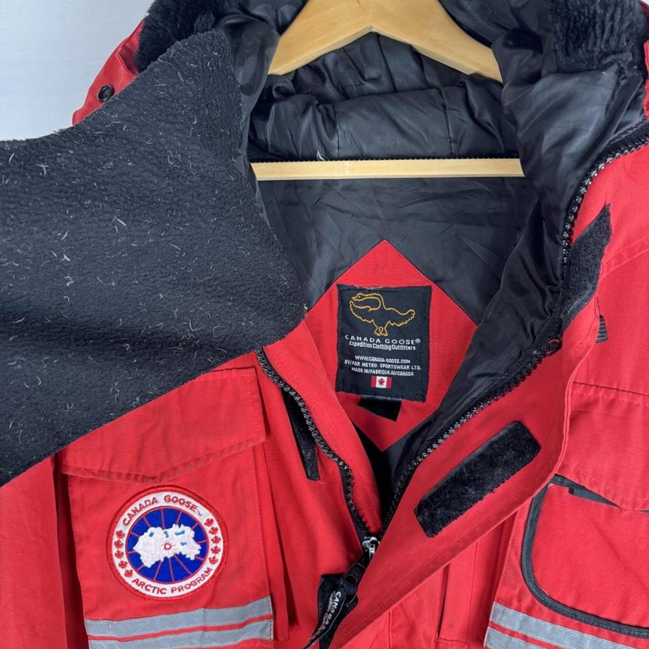 Canada Goose red parka jacket with logo patch and thick insulated material.