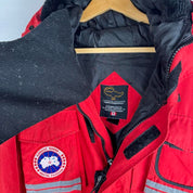Canada Goose red parka jacket with logo patch and thick insulated material.