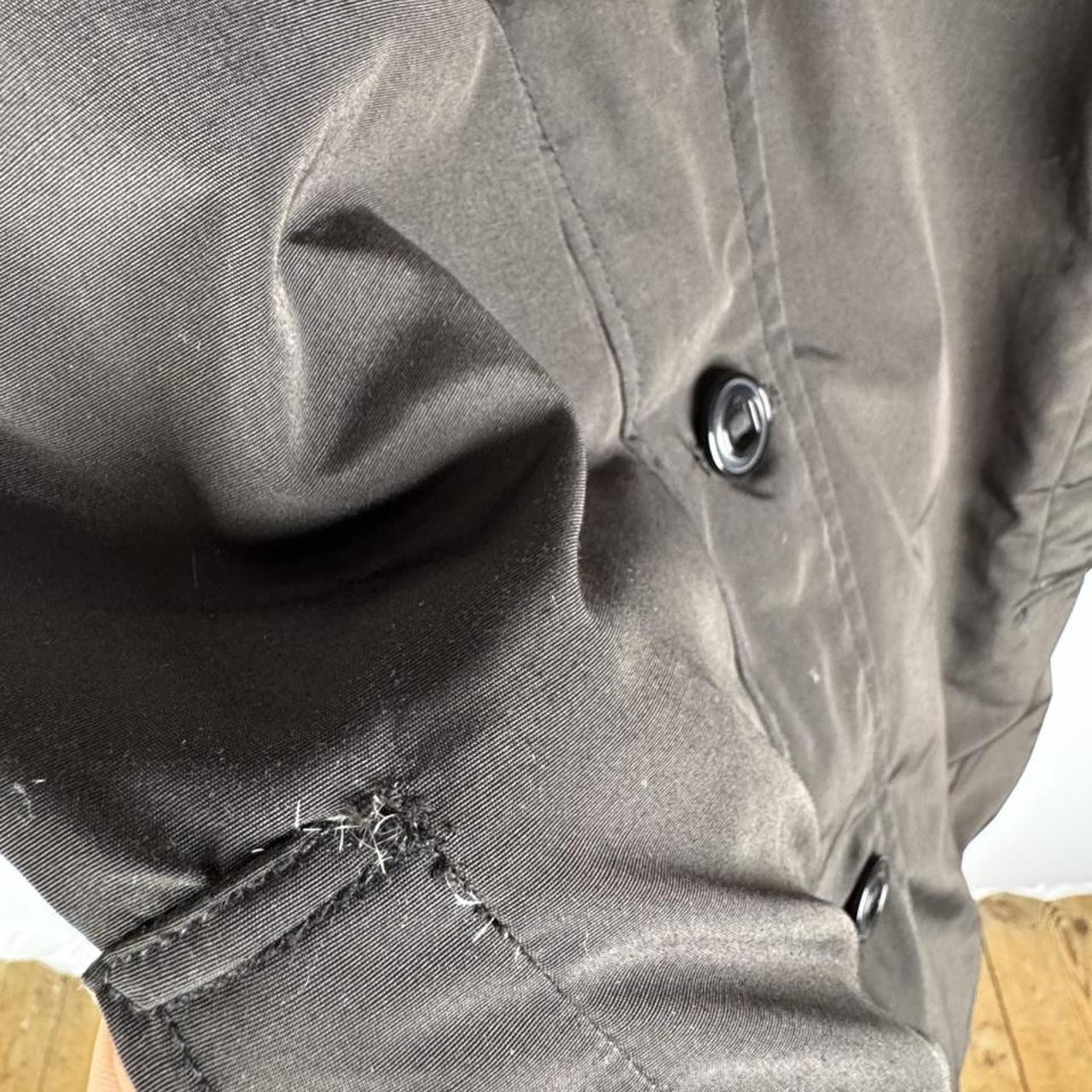 Canada Goose black parka jacket with logo, slight tear near pocket, missing hood.