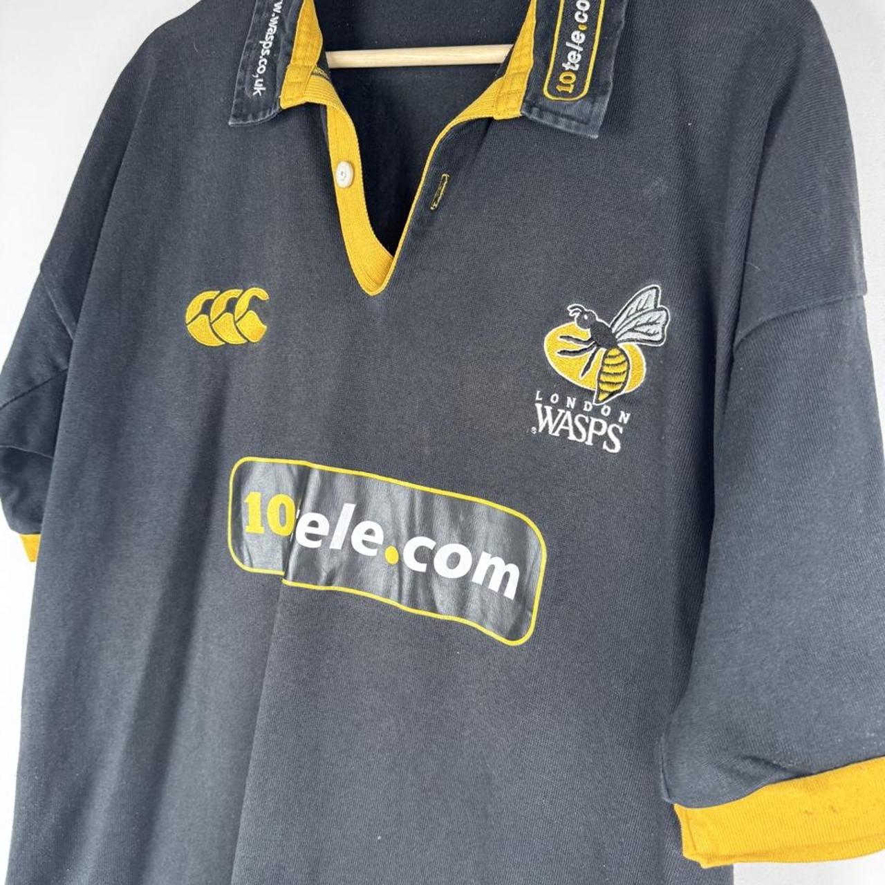 Canterbury men's rugby polo shirt, black and gold, featuring Wasps logo and classic design.
