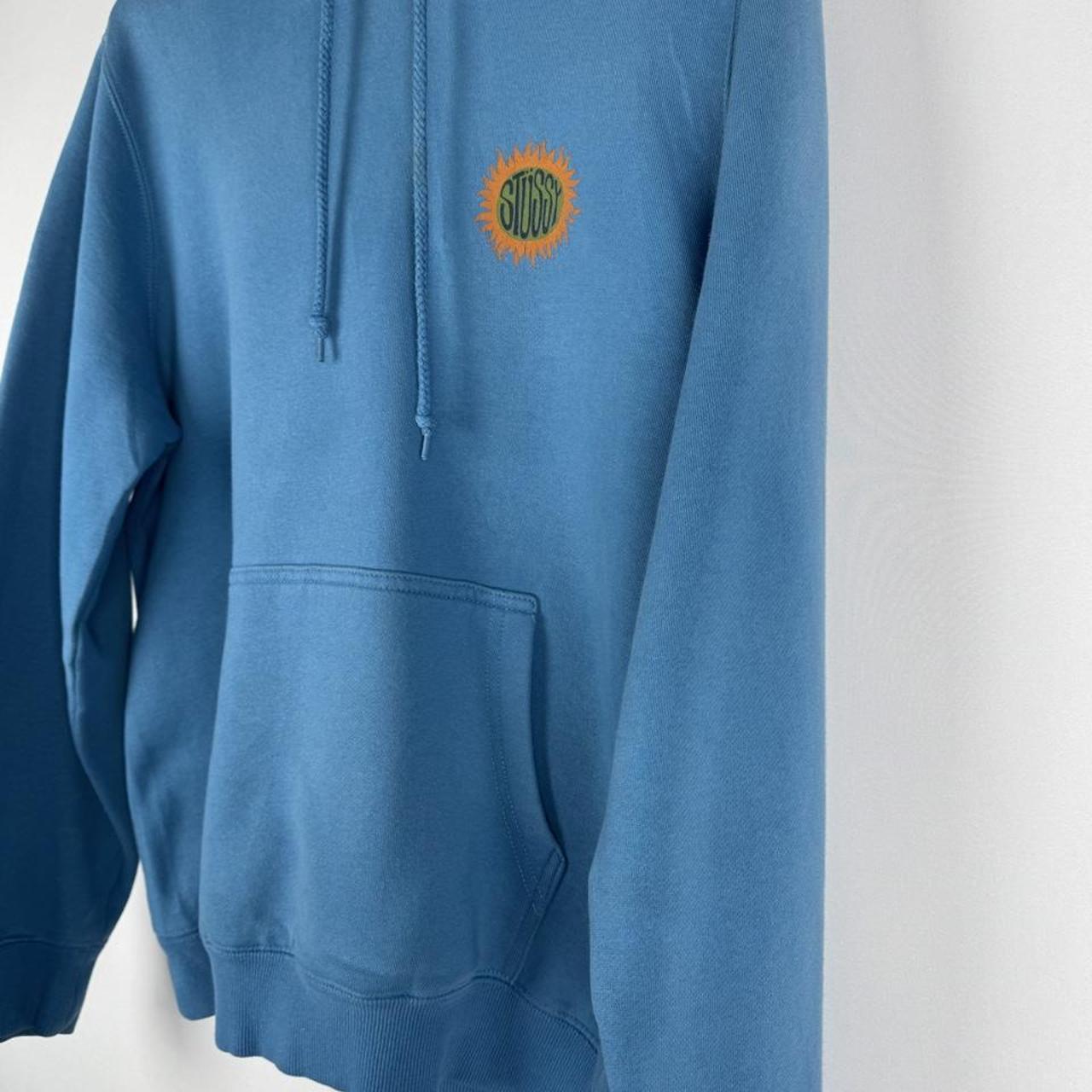 Stüssy graphic hoodie in grey with colorful sun print and logo detail.