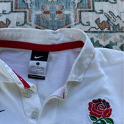 Nike black and white rugby polo shirt with England logo and striped pattern.