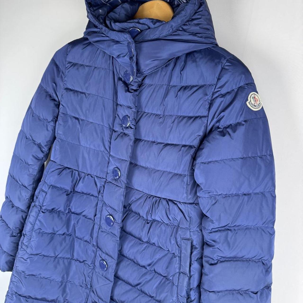 Moncler blue puffer jacket with logo detail and quilted design.