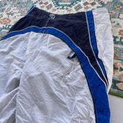 Billabong board shorts blue with tropical print and Andy Irons logo detail.