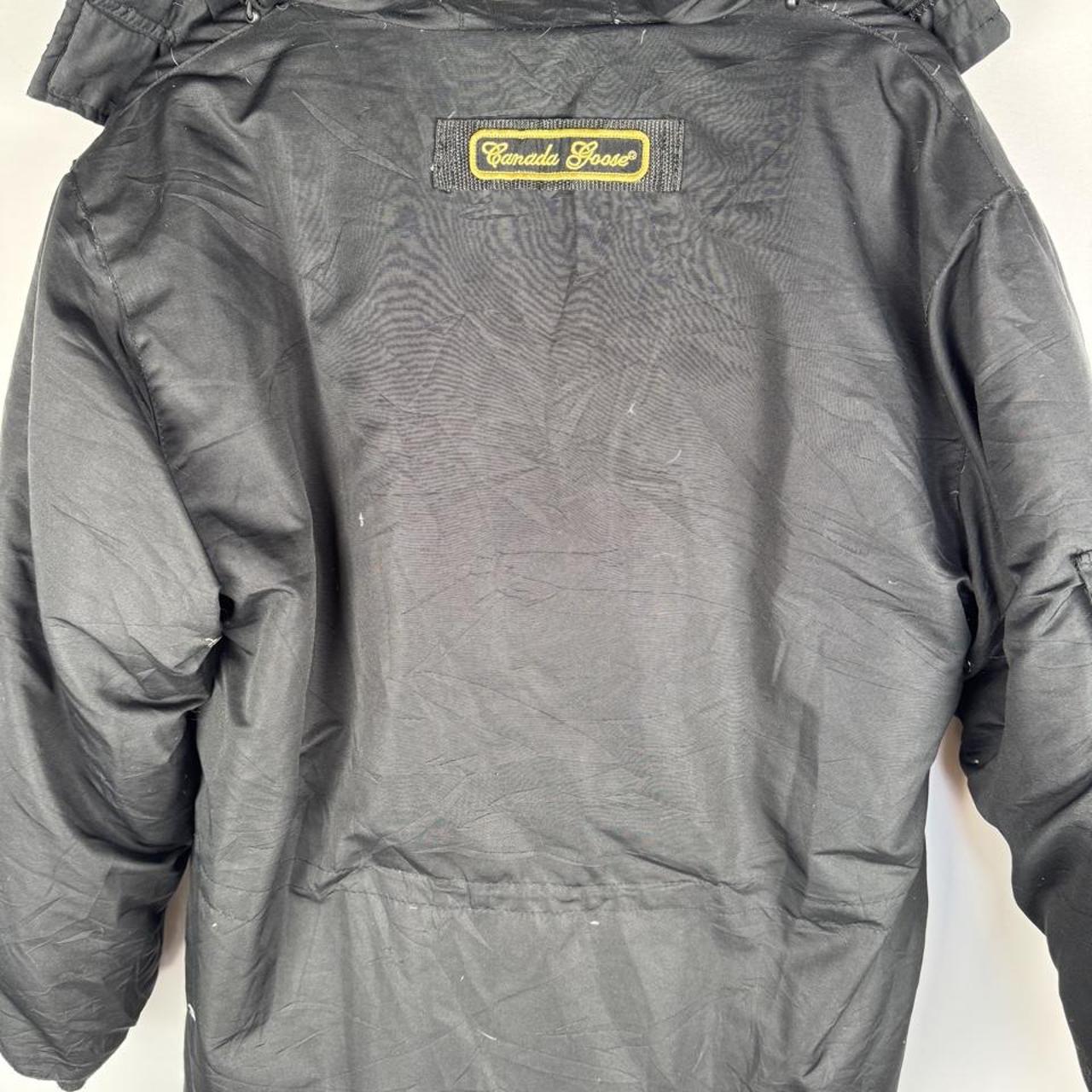 Canada Goose black and brown parka jacket with logo and utility pockets.