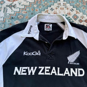 Kooga men's polo shirt, green with embroidered New Zealand logo and rugby collar.
