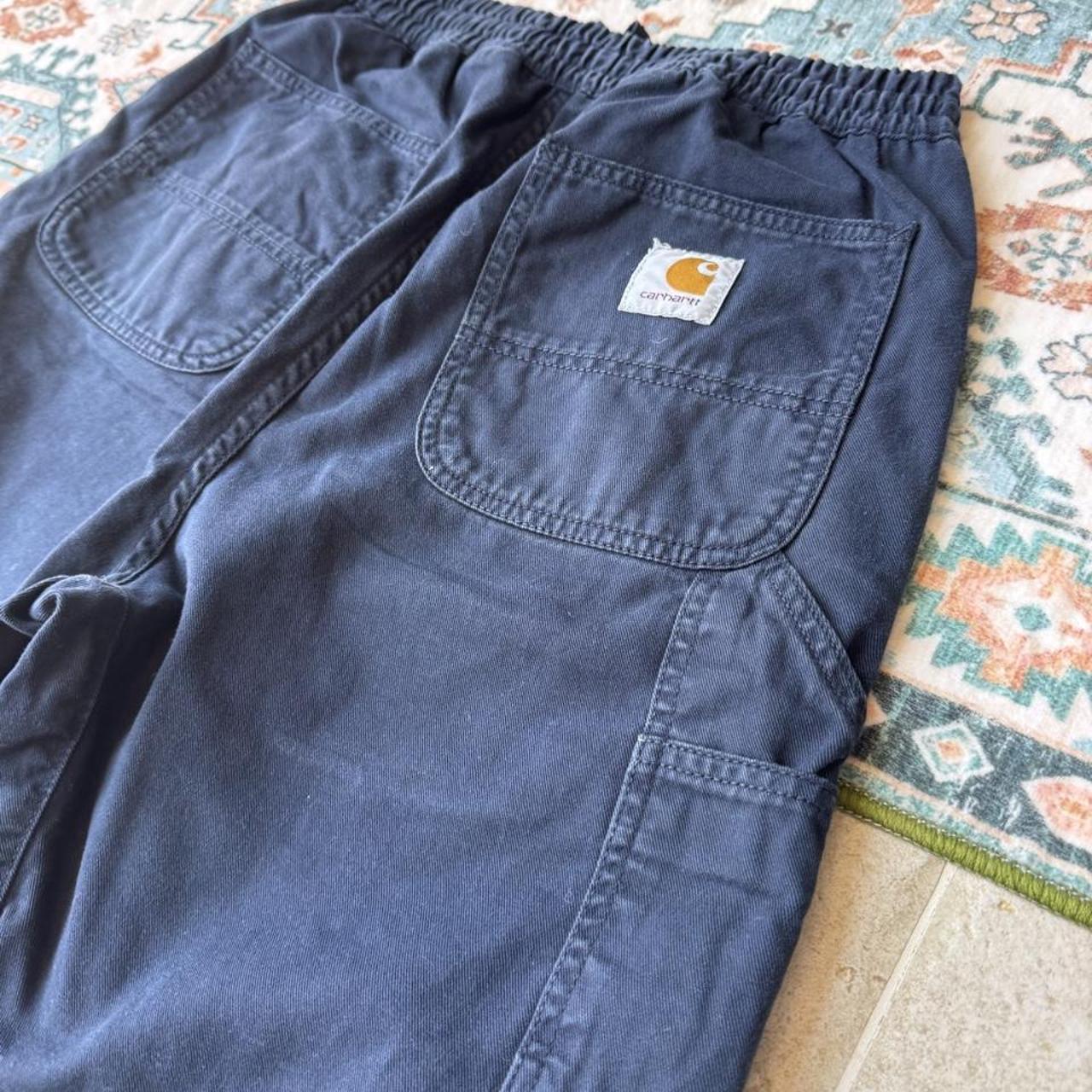 Carhartt WIP navy shorts with logo patch and durable cotton material.