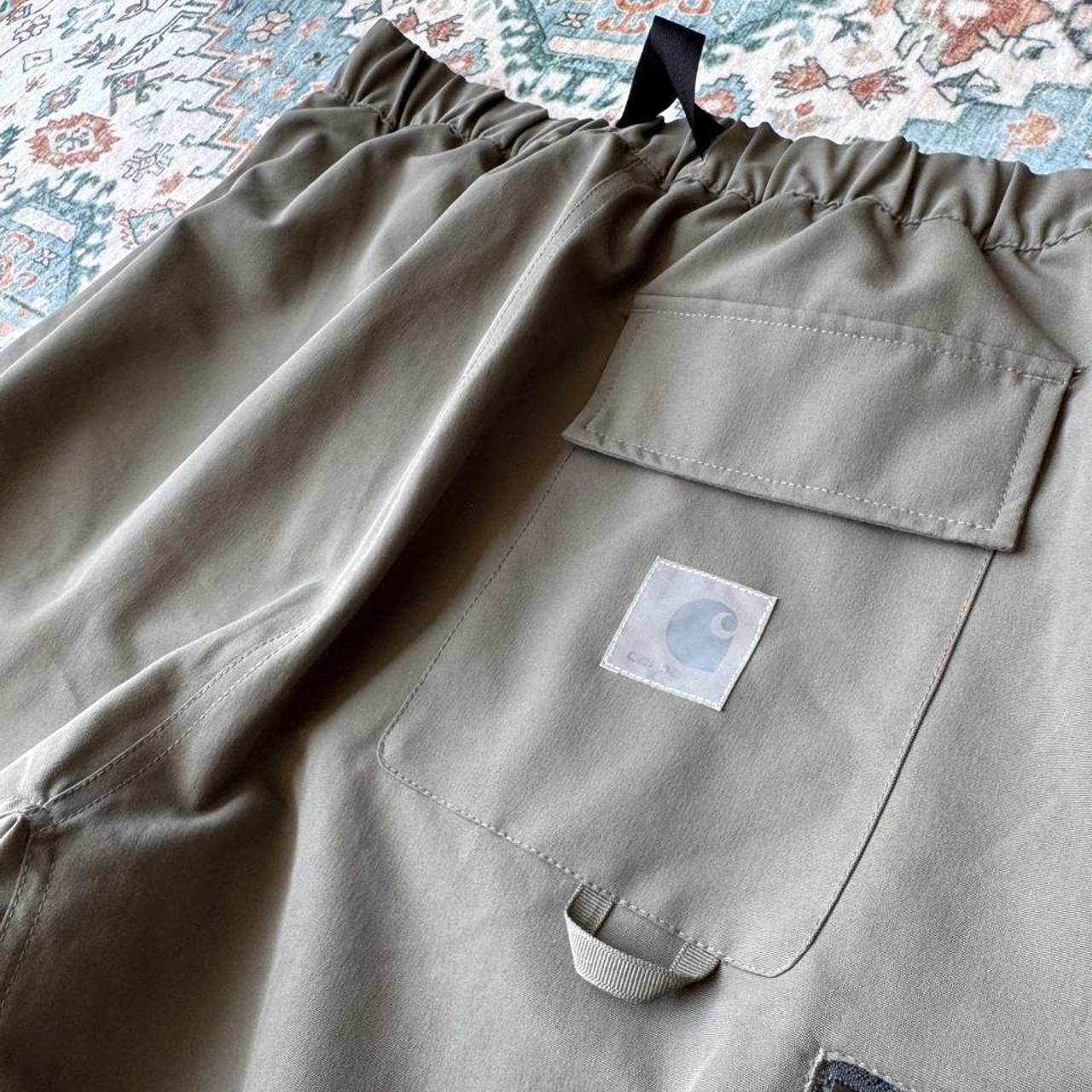 Carhartt WIP olive green cargo shorts with multiple pockets and logo patch.
