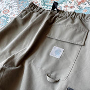 Carhartt WIP olive green cargo shorts with multiple pockets and logo patch.
