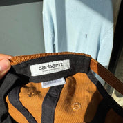 Carhartt WIP hat brown corduroy with embroidered logo and rugged design.