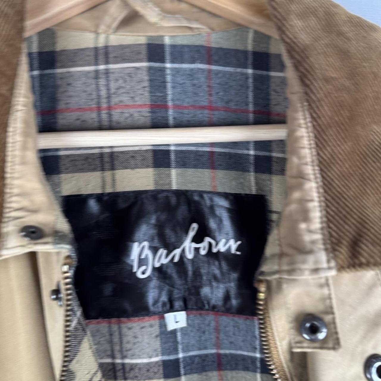 Barbour cream jacket with coated cotton, classic design, relaxed fit, visible marks.