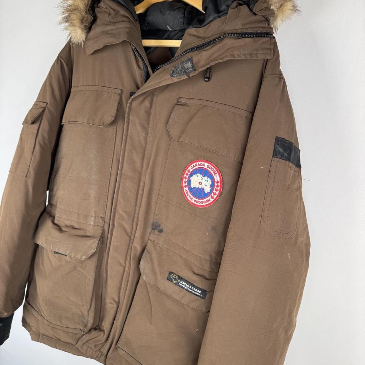 Canada Goose brown parka jacket with logo patch and utility pockets.