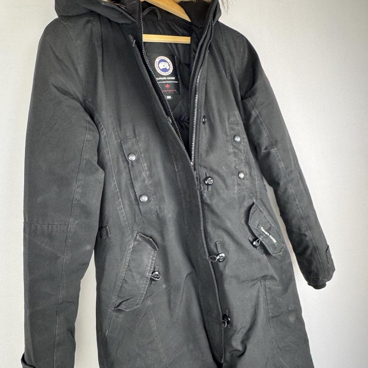 Canada Goose black parka jacket with logo patch and fur-lined hood.